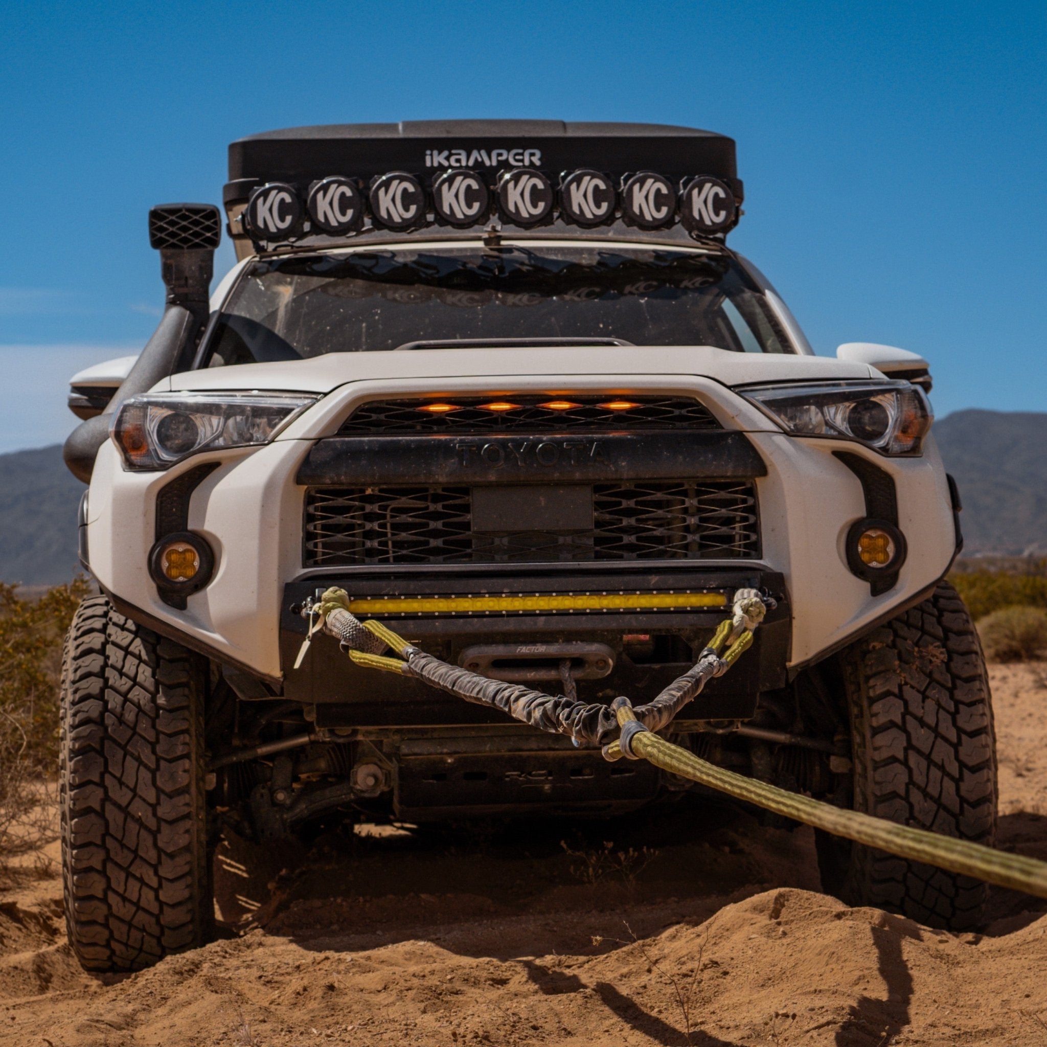 Front view of a Toyota 4Runner using a Kinetic-X static bridle and winch setup for vehicle recovery in deep sand with soft shackles and protective sleeves.