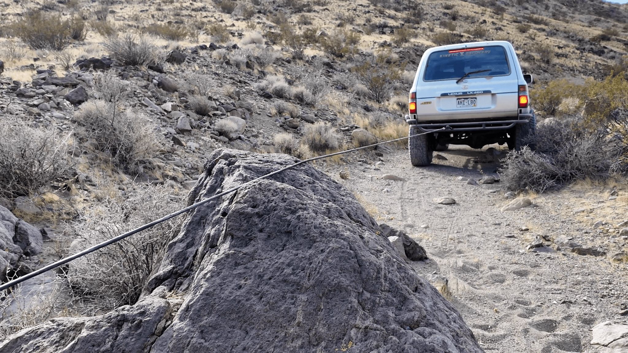 Armored synthetic winch line dragging rock